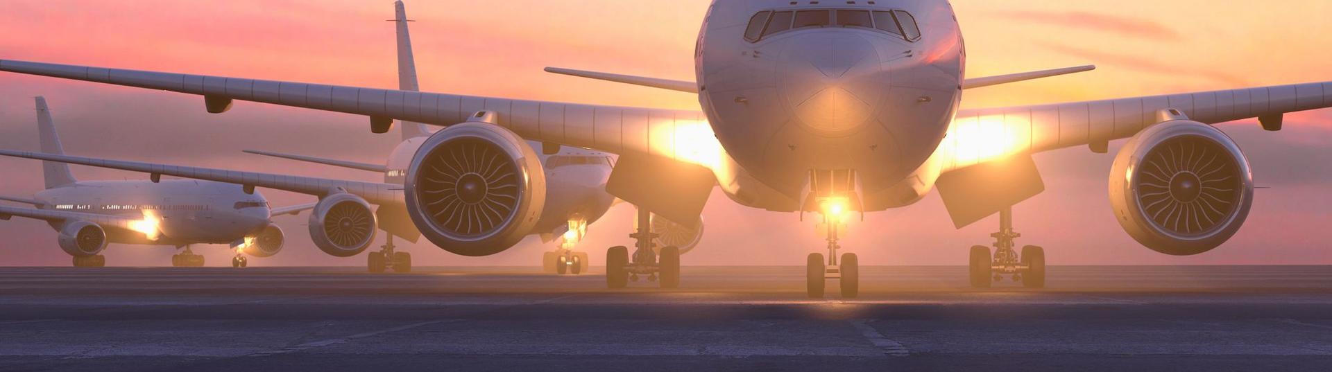 airplane on runway with sunset behind