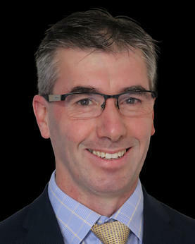 Man smiling at the camera wearing glasses