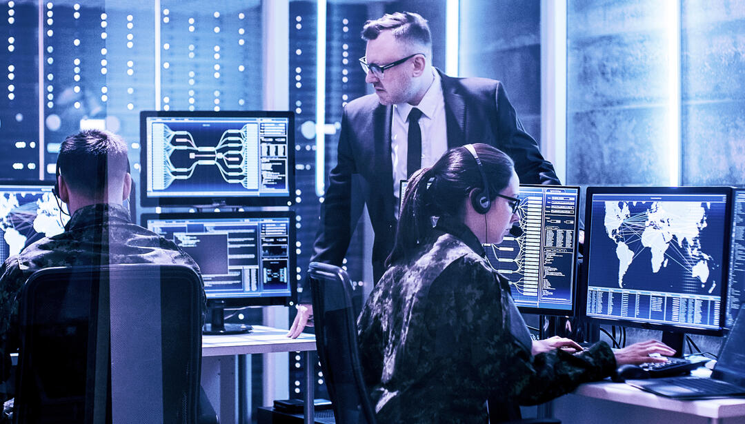group of people working in server room on computers