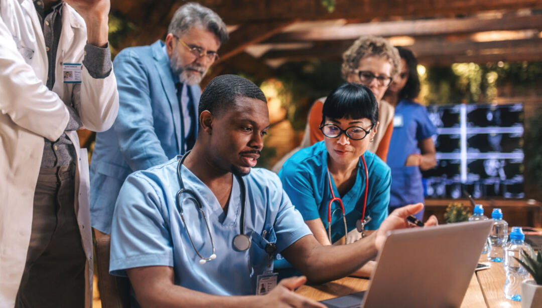 a group of medical staff working on a laptop