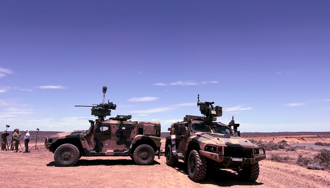 Two armored vehicles on a gravel road