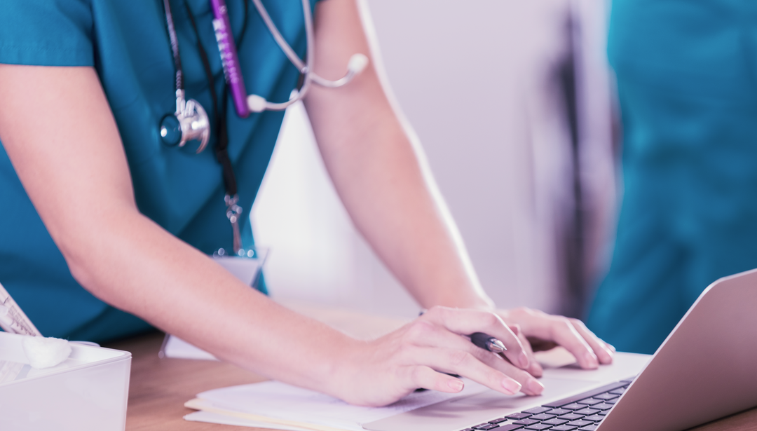 Healthcare practitioner working on a laptop