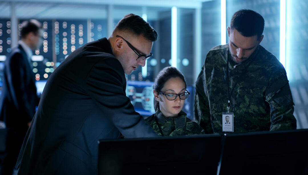 Military and intelligence personnel looking at computer