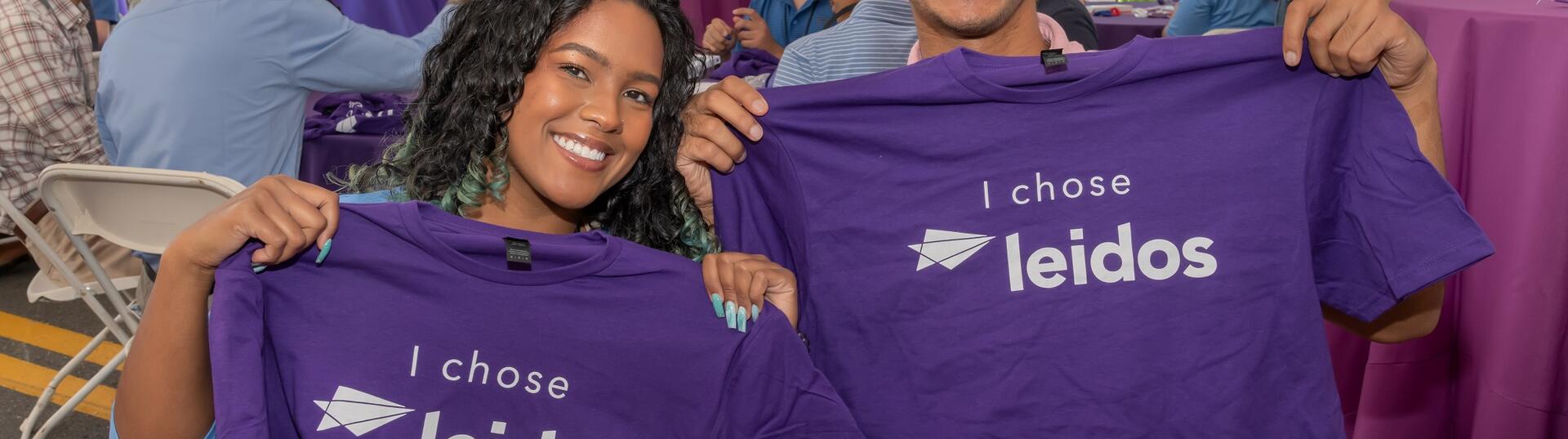 Picture of two interns holding tshirts