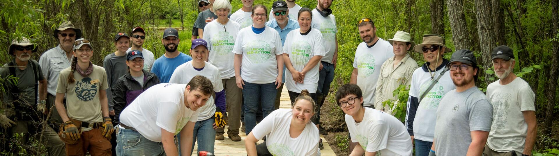 Leidos employees building a boardwalk for access to a nature preserve.