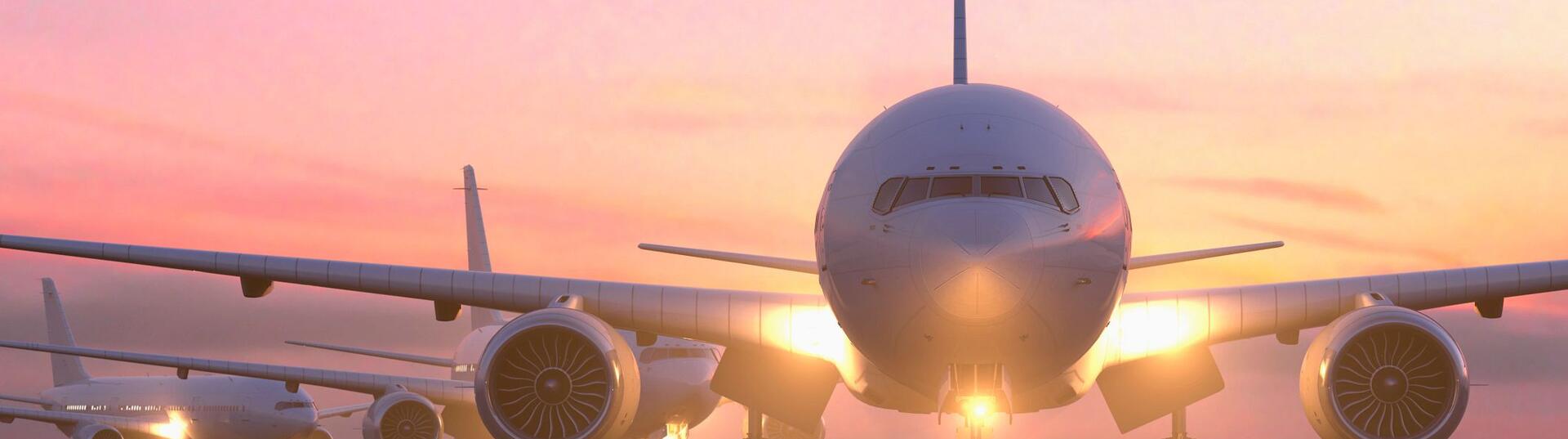 airplane on runway with sunset behind