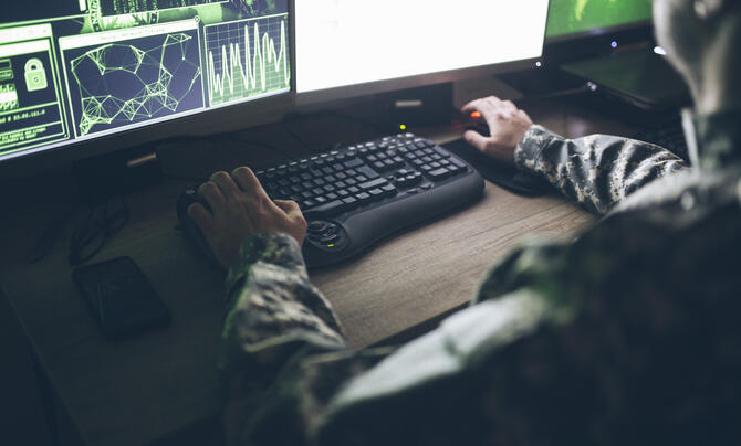 Offensive cyber operator sits at their desk 