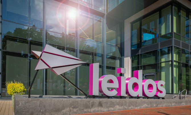A large metal Leidos logo and wordmark in front of Leidos headquarters
