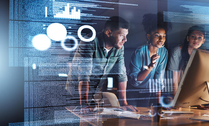 Three people standing up looking at a computer screen.