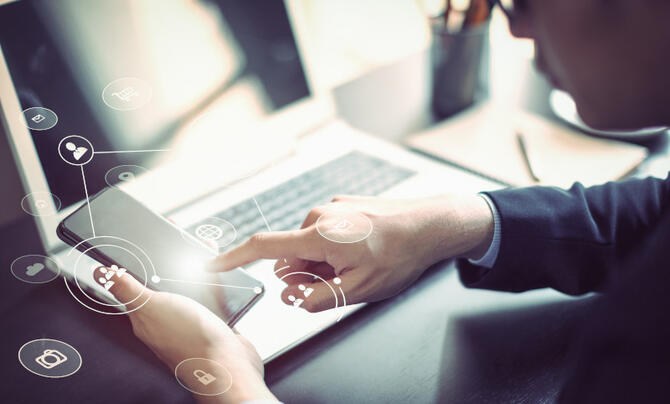 Person using mobile phone and laptop connected