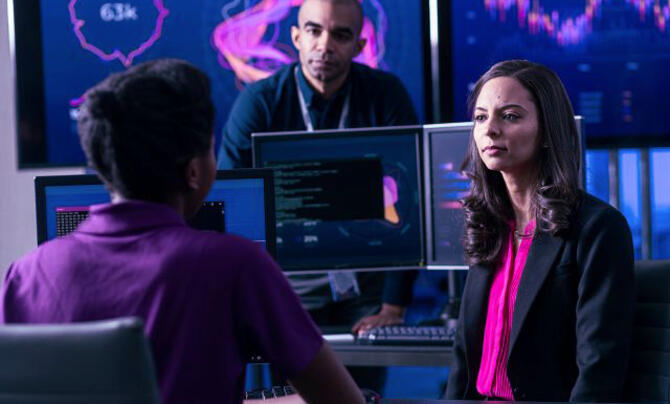 team working in a SCIF with large monitors behind them