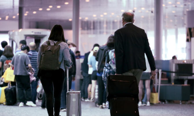 Passengers at an airport walking through the concourse