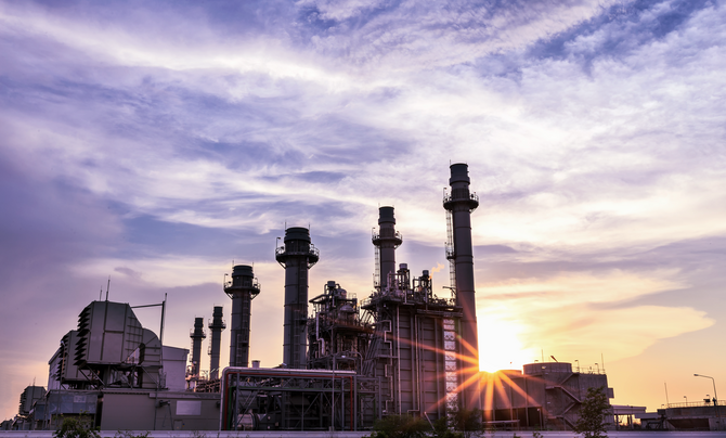 Sun setting behind a power plant