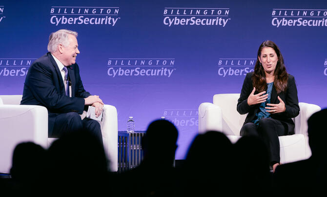 Two speakers discuss cybersecurity on stage during a panel at the 2026 Billington CyberSecurity Summit.