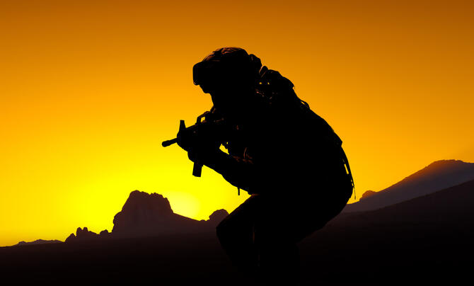 silhouette of person holding a machine gun 
