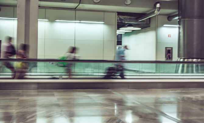 people walking through moving walkway