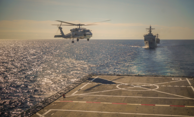 helicopter landing on a carrier at sea