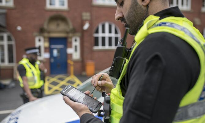 police offer using digital device at crime scene