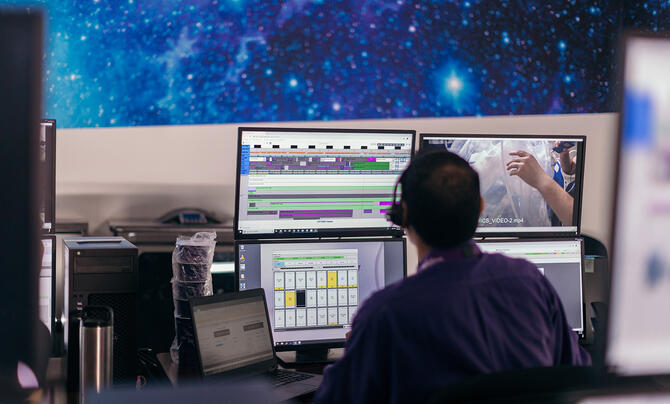 An employee working at his desk at the Leidos Operations Center supporting NASA and astronauts on the International Space Station
