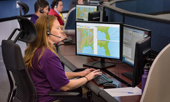 photo of a command center with employees on their computers supporting the FAA