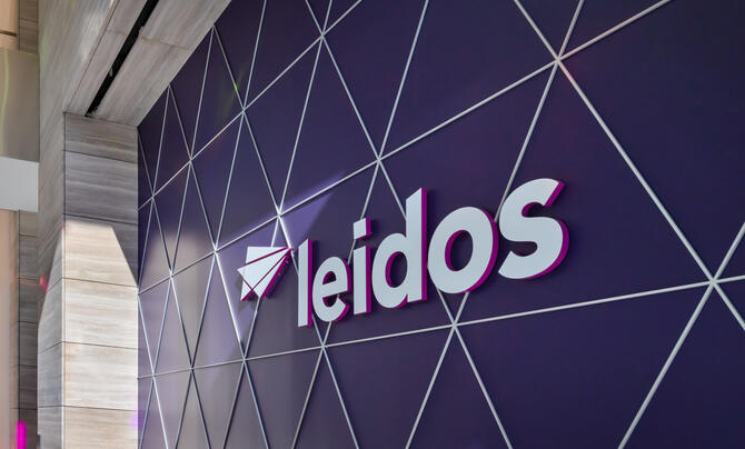 Leidos logo against a purple wall