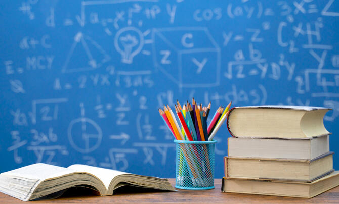 STEM scholarship with books and pencils with chalk board background