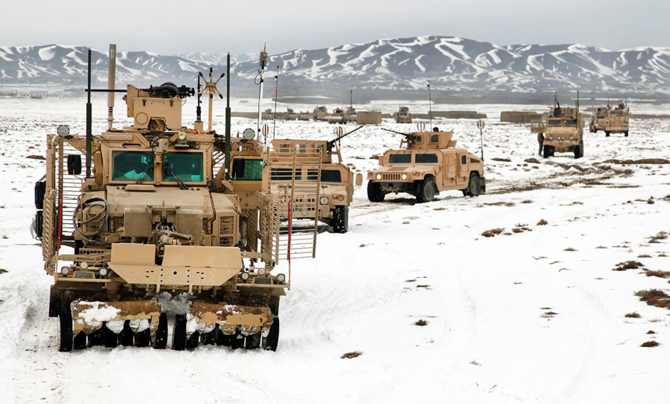 Humvees in a caravan driving through snow