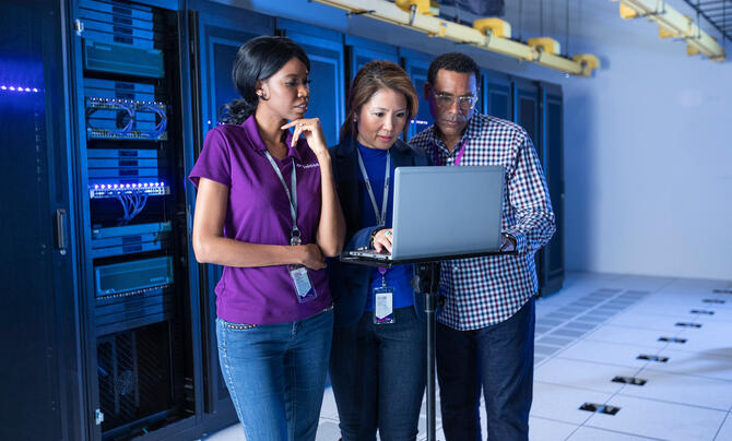Leidos employees looking at laptop