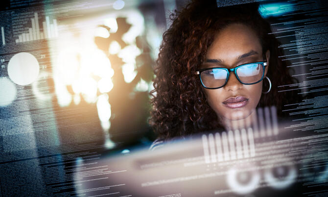 woman looking at screen with reflection of screen on her glasses