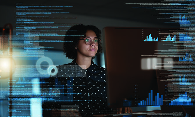 Woman with holographic information in front of computer screen