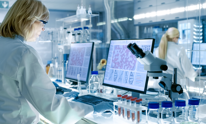female scientist in the lab reviewing results on a computer 