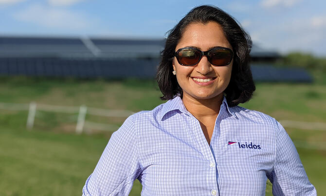 Photo of Amruta Kalvit with solar arrays in background