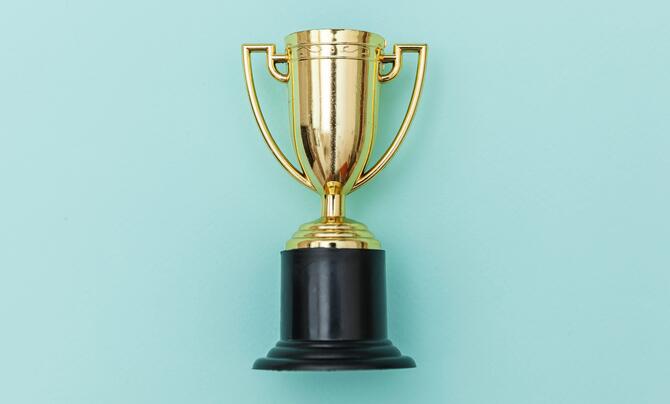 A gold trophy on a light green background