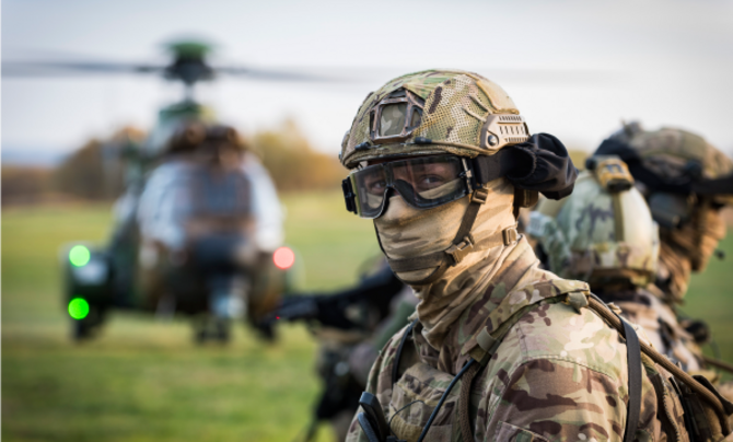 UK Army Soldier with uniform and helicopter in the background