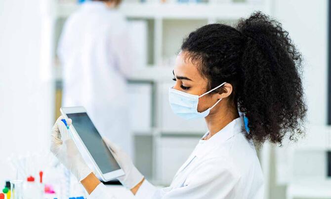 women in lab using tablet