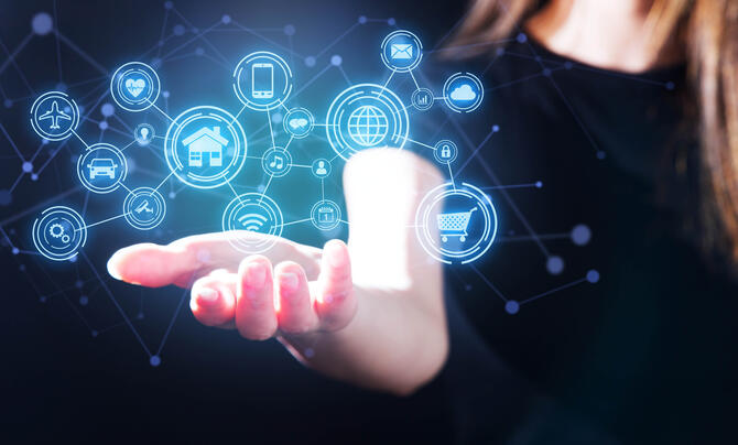 Woman holding holograph of icons, representing Internet of Things