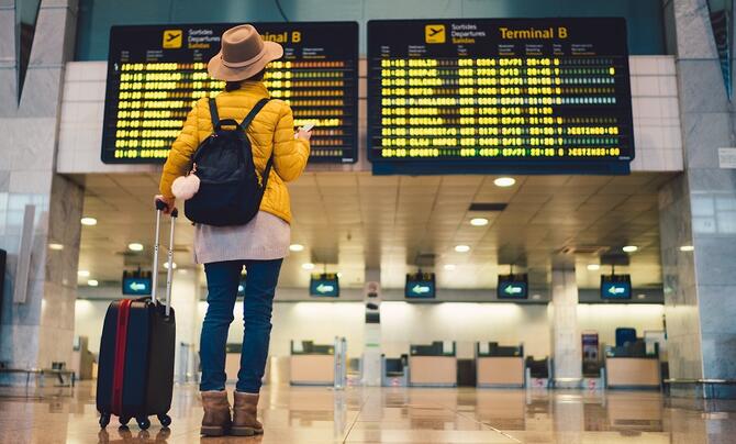 Traveler looking at flight board in airport