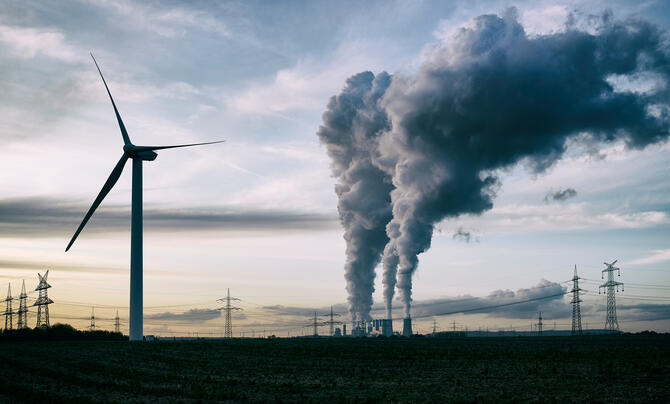wind turbine with energy plant in background 