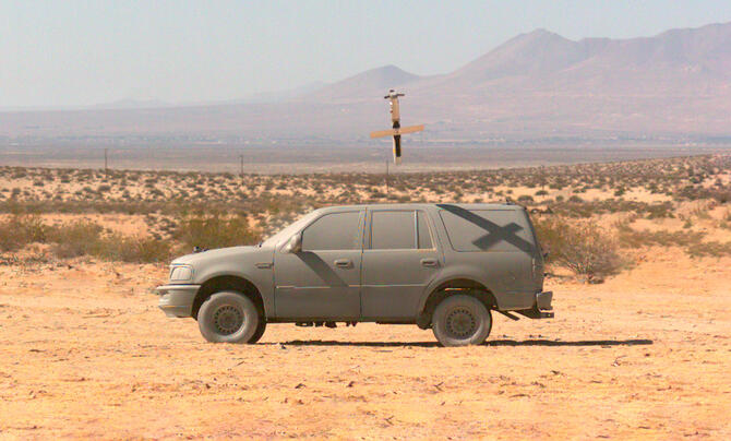 Representative image of test area showing open area and a vehicle covered in desert sand