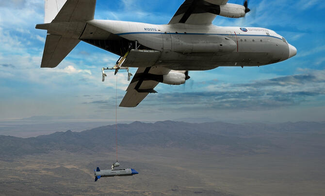 C-130 flying with the X-61A Gremlins Air Vehicle in formation