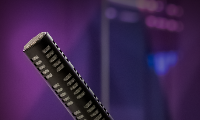 A podcast studio with a microphone and Leidos colors in the background