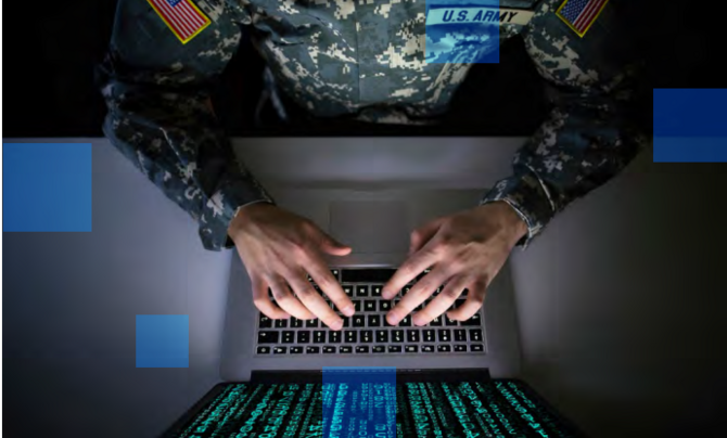 A person in a military uniform typing at a laptop