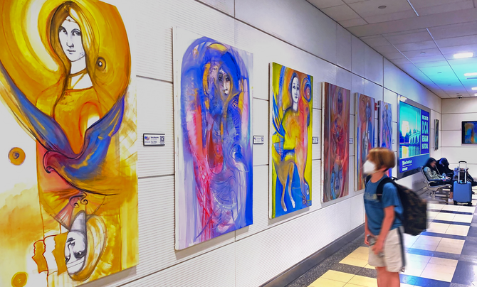 A young traveler takes a moment to appreciate the beauty of a painting inside an airport terminal