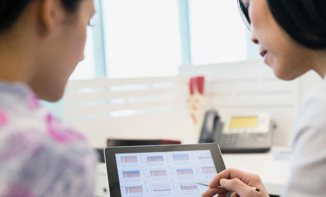 doctor and nurse looking at health results on a screen