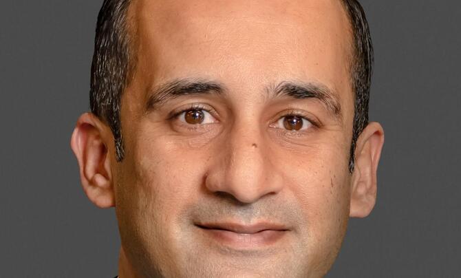 Masood Ahmed pictured in front of a gray background