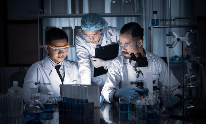 Scientists working in a lab huddled around a computer