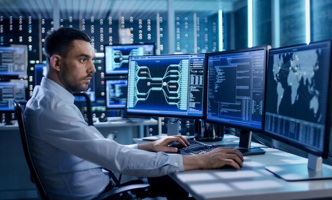 Security specialist working at a data center with multiple monitors displaying information