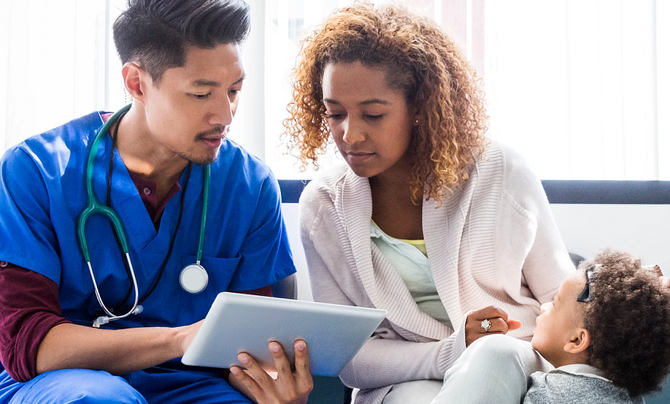 A doctor consulting with patients using a tablet device