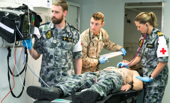 A patient lying on a table surrounded by three medical staff 