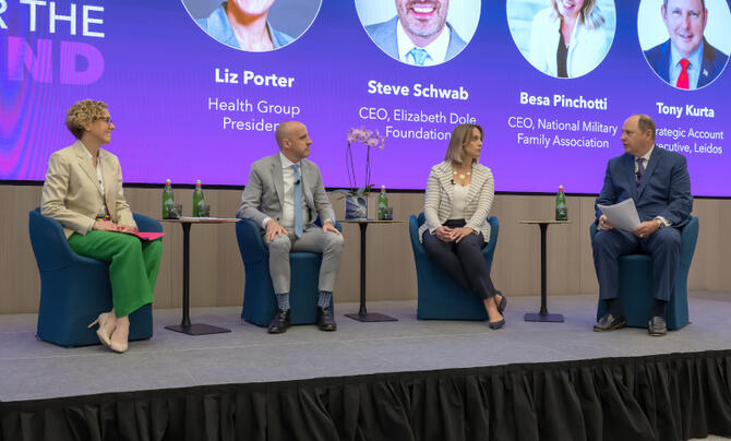 A group of people sitting in a panel on a stage